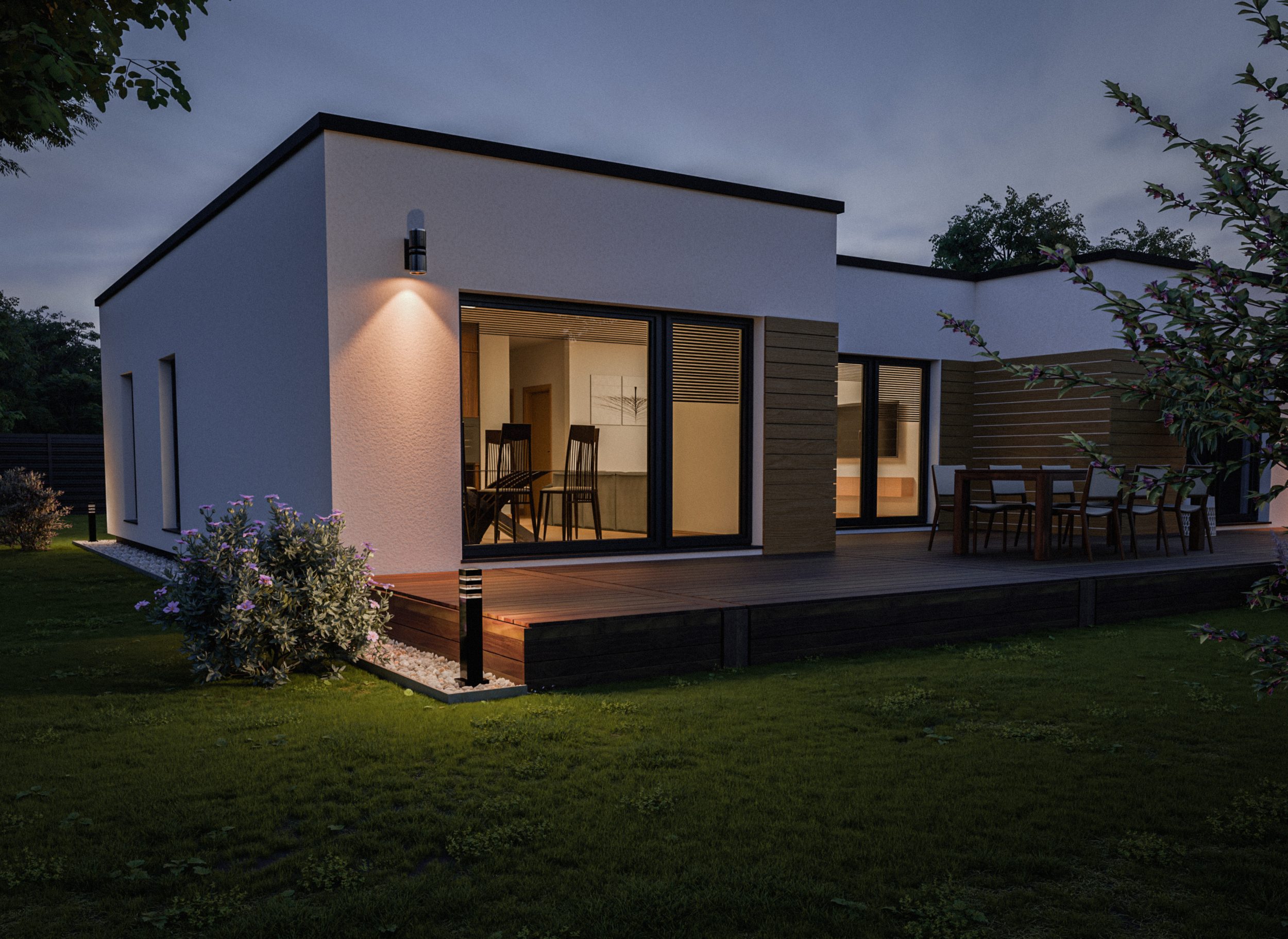 Večerna slika moderne pritlične hiše, skozi okna je opazna jedilnica s kuhinjo in dnevna soba.